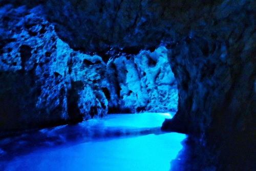 inside of a blue cave with sun illuminating the cave with blue light