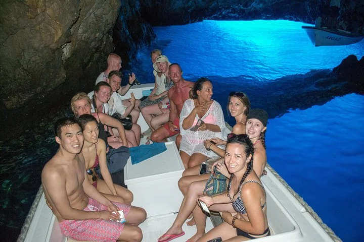 people inside blue cave croatia on a small wooden boat